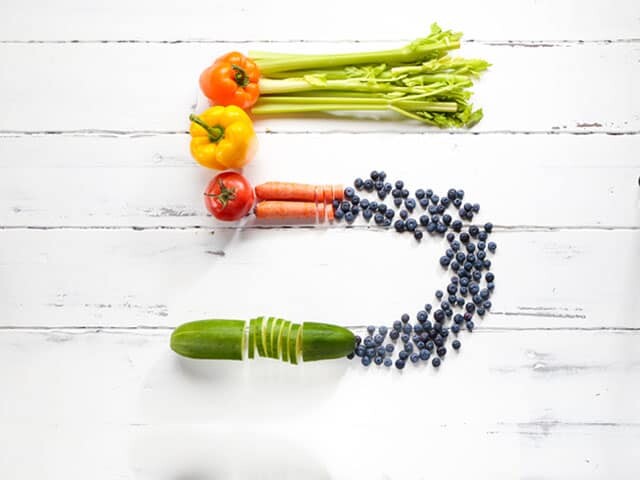 Different vegetables and fruit arranged as the number 5