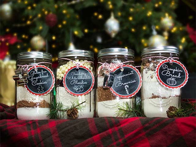 Four jars of different baked goods in front of Christmas tree