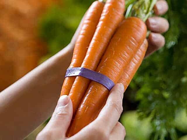 Organic Food Benefits: Woman holding a Bunch of Fresh Carrots