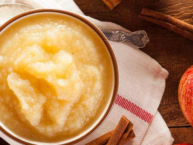 Bowl of applesauce with cinnamon sticks