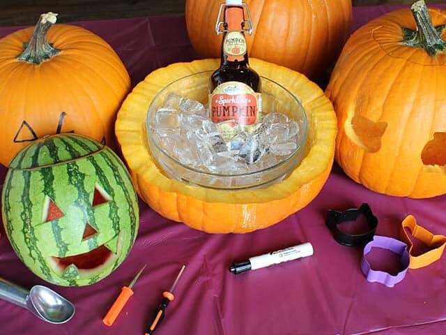 Carved pumpkins and a watermelon with Sparkling Pumpkin Beverage on ice