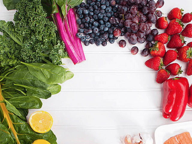 groups of colorful fruits and vegetables on white wood