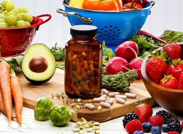 Fruits, vegetables and vitamins on cutting board