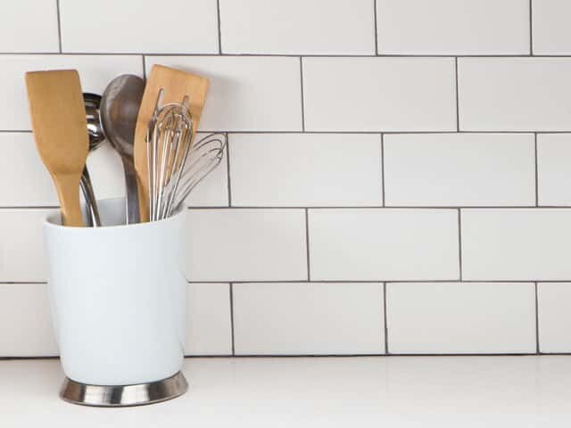 Container of utensils on kitchen counter