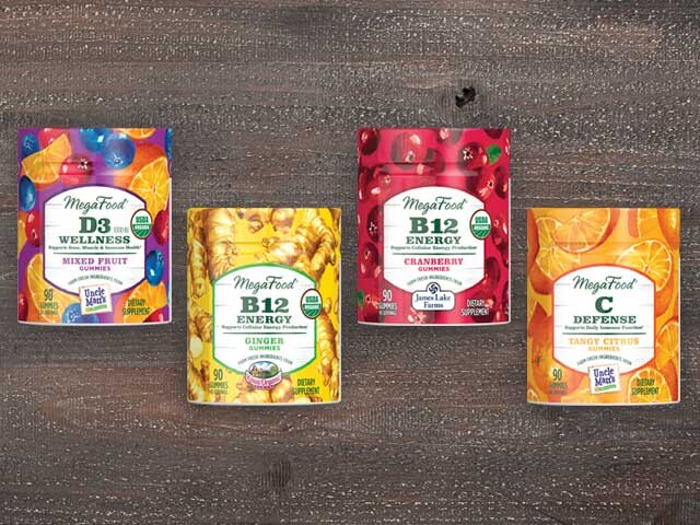 four packages of MegaFood gummies on a wood background