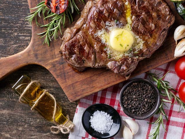 Keto Diet grilled steak with butter, garlic, tomatoes and spices feature