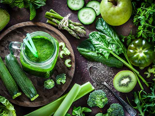 A plate full of green vegetables and fruit