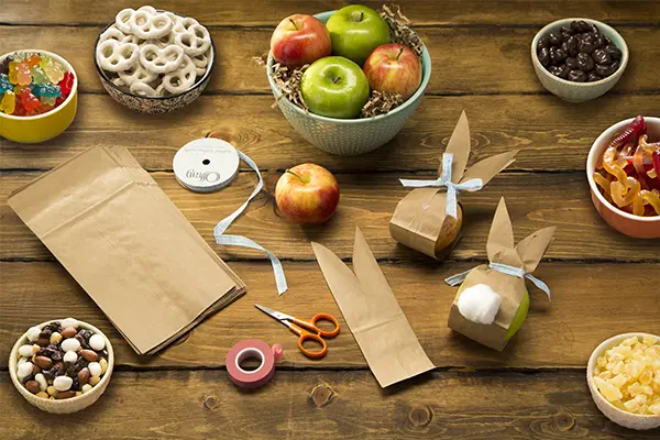 easter sweets in bowls around paper bag bunnies