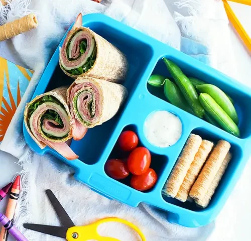 turkey rolls in a bento box with veggies