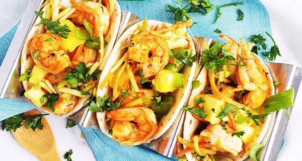 three jerk shrimp tacos on a serving dish