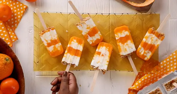 mandarin orange cream popsicles on a serving board