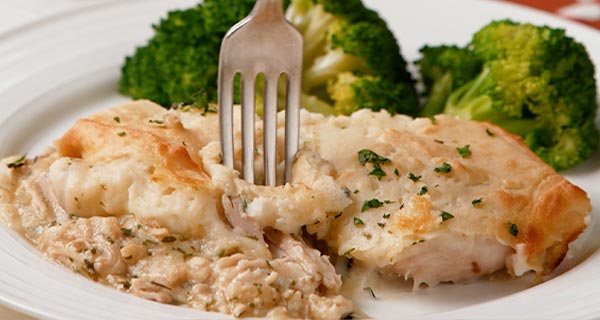 potato & turkey casserole on a plate with broccoli