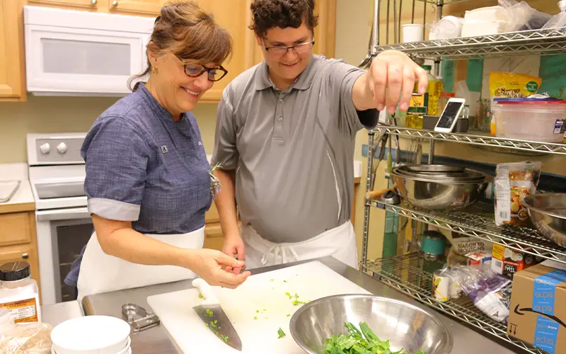 Woman teaching a man how to cook