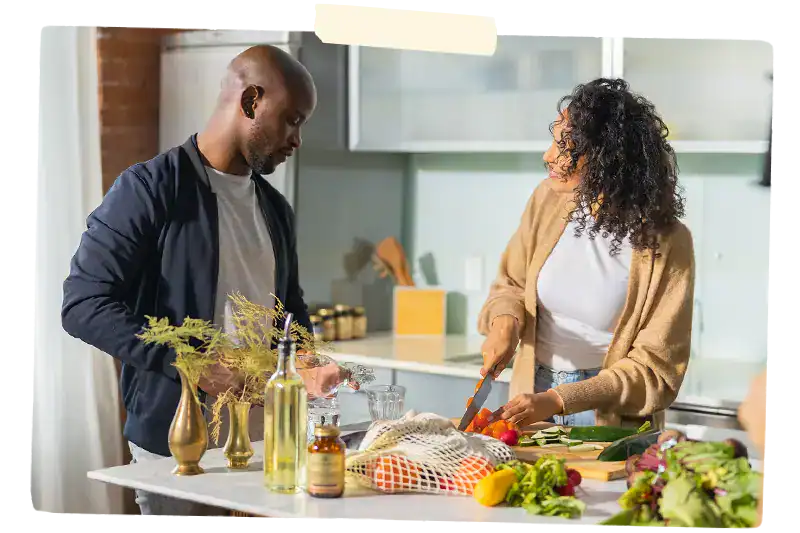 Man and woman cooking around a table